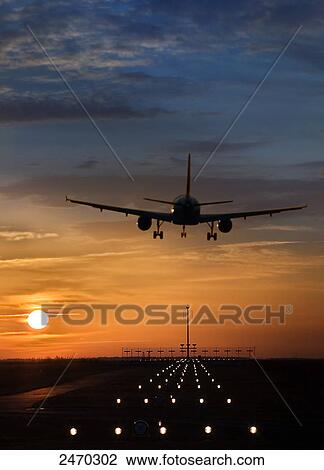 Stock Image - Airplane taking off from runway at dusk . Fotosearch