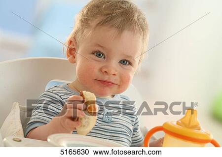 Baby eating at table View Large Photo Image Stock Image - Baby eating at table . Fotosearch