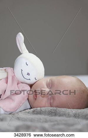 Stock Photograph - Baby sleeping with stuffed animal, close-up . Fotosearch