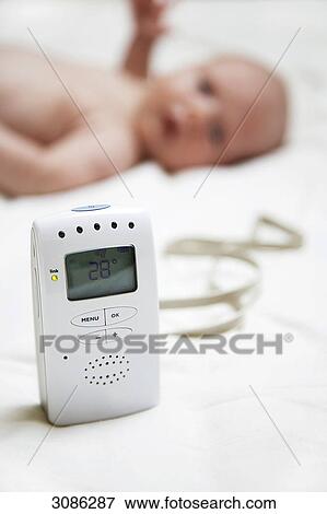 Babyphone, Baby lying in the background View Large Photo Image Stock Photo - Babyphone, Baby lying in the background . Fotosearch