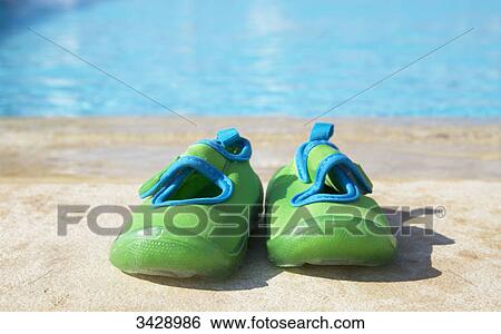 Stock Photograph - Bathing shoes by pool side, close-up . Fotosearch
