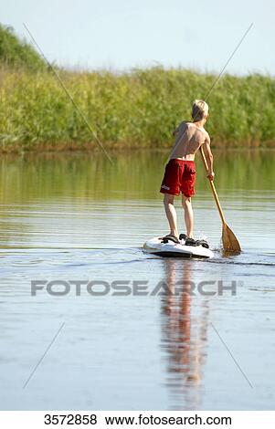 Boy paddling on river Alte Sorge, Bergenhusen, Schleswig-Holstein, Germany, Europe View Large Photo Image Stock Photo - Boy paddling on river Alte Sorge, Bergenhusen, Schleswig-Holstein, Germany, Europe . Fotosearch