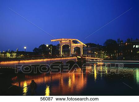 Stock Photo - Bridge over river illuminated at night, Amsterdam, Netherlands, Europe . Fotosearch