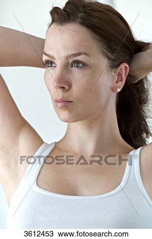 Stock Image - Brunette woman wearing undershirt, portrait . Fotosearch