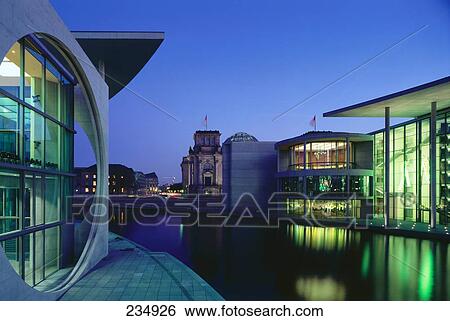 Stock Photograph - Buildings lit up at dusk, Marie-Elisabeth-Lueders-Haus, Spree River, Berlin, Germany . Fotosearch