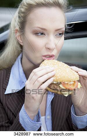 Businesswoman eating a hamburger View Large Photo Image Stock Photo - Businesswoman eating a hamburger . Fotosearch