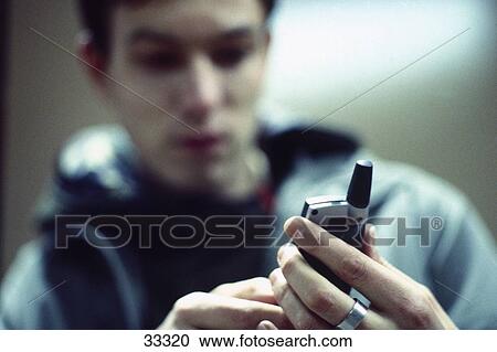 Stock Image - Close-up of a young man using a mobile phone . Fotosearch