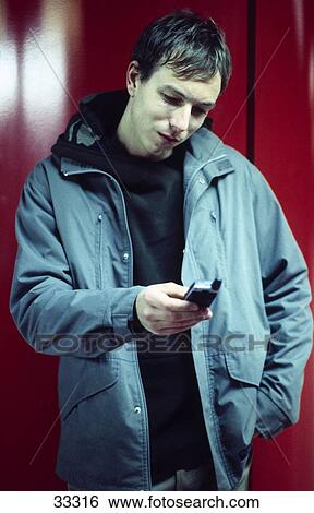 Close-up of a young man using a mobile phone View Large Photo Image Stock Photograph - Close-up of a young man using a mobile phone . Fotosearch