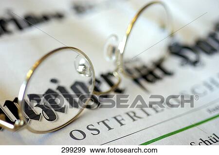 Stock Photo - Close-up of eyeglasses on newspaper . Fotosearch