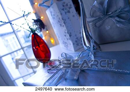 Stock Image - Close-up of flowers in vase and shopping bag beside it . Fotosearch