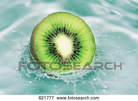 Stock Photo - Close-up of slice of kiwi fruit dipping in water . Fotosearch