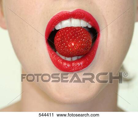 Stock Image - Close-up of woman eating strawberry . Fotosearch