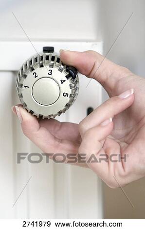 Stock Photo - Close-up of woman's hand adjusting knob . Fotosearch