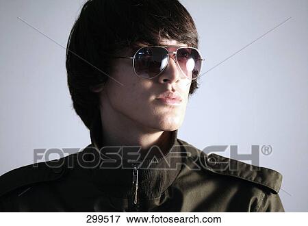Close-up of young man wearing sunglasses View Large Photo Image Stock Photo - Close-up of young man wearing sunglasses . Fotosearch
