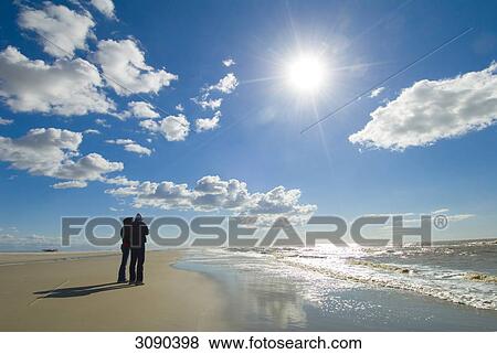 Couple standing at beach, Sankt Peter-Ording, Schleswig-Holstein, Germany View Large Photo Image Stock Photo - Couple standing at beach, Sankt Peter-Ording, Schleswig-Holstein, Germany . Fotosearch