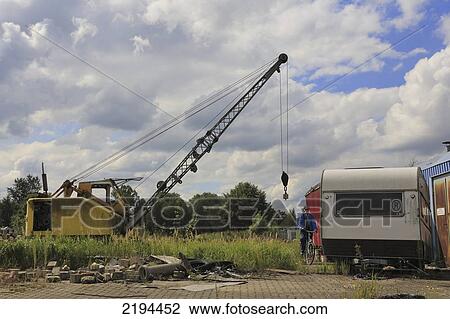 Stock Image - Crane and mobile home in field, Finkenwerder, Hamburg, Germany . Fotosearch