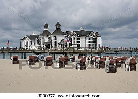 Stock Image - Empty beach chairs in front of the pier of Sellin, Rugia, Germany . Fotosearch