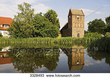 Stock Image - Fieldstone church at a pond in Lindenberg, Ahrensfelde, Germany . Fotosearch