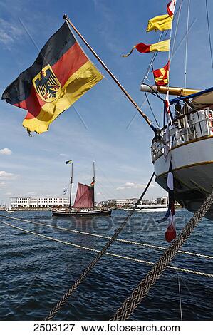 Stock Photo - German flag on ship anchored at harbor, Warnemunde, Mecklenburg-Vorpommern, Berlin, Germany . Fotosearch