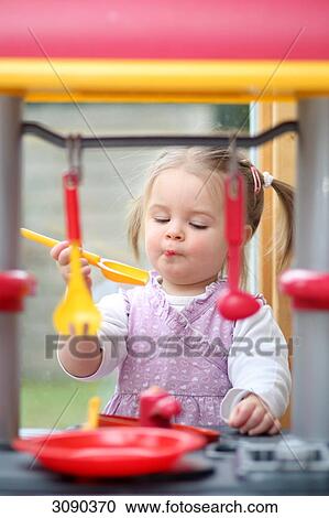 Girl cooking in a play kitchen View Large Photo Image Stock Image - Girl cooking in a play kitchen . Fotosearch