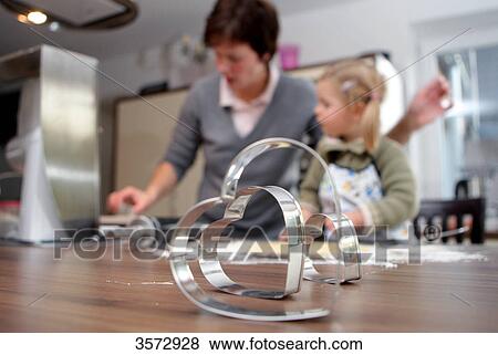 Girl helping mother baking biscuits View Large Photo Image Stock Photo - Girl helping mother baking biscuits . Fotosearch