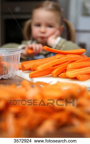 Picture - Girl helping peeling carrots . Fotosearch