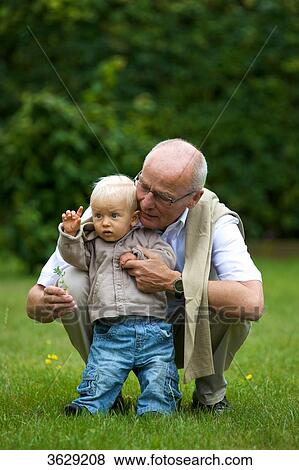 Stock Photo - Grandfather and toddler in meadow . Fotosearch