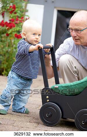 Grandfather and toddler with doll's pram outdoors View Large Photo Image Stock Image - Grandfather and toddler with doll's pram outdoors . Fotosearch