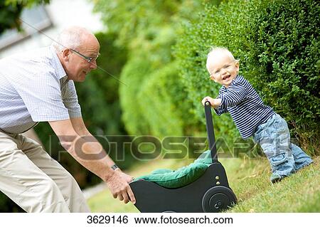 Grandfather and toddler with doll's pram outdoors View Large Photo Image Stock Photograph - Grandfather and toddler with doll's pram outdoors . Fotosearch