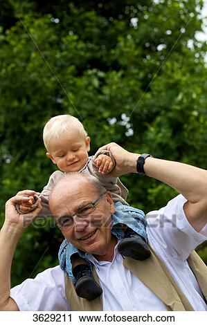 Grandfather carrying toddler on shoulders, portrait View Large Photo Image Stock Image - Grandfather carrying toddler on shoulders, portrait . Fotosearch