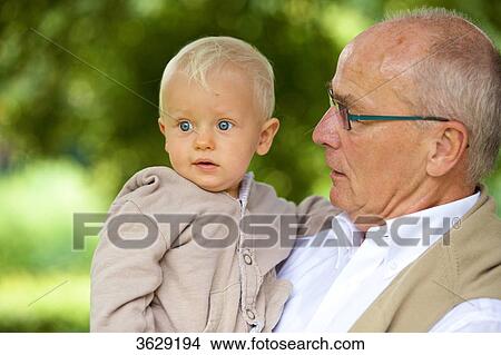 Grandfather carrying toddler outdoors, portrait View Large Photo Image Picture - Grandfather carrying toddler outdoors, portrait . Fotosearch