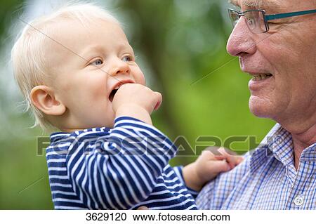 Grandfather carrying toddler outdoors, portrait View Large Photo Image Stock Image - Grandfather carrying toddler outdoors, portrait . Fotosearch