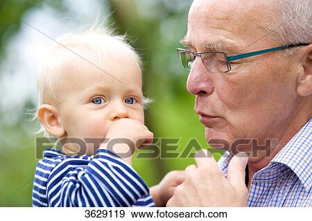 Grandfather carrying toddler outdoors, portrait View Large Photo Image Stock Photo - Grandfather carrying toddler outdoors, portrait . Fotosearch