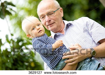 Grandfather carrying toddler outdoors View Large Photo Image Stock Photo - Grandfather carrying toddler outdoors . Fotosearch