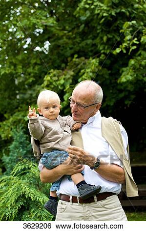 Grandfather carrying toddler outdoors View Large Photo Image Stock Photograph - Grandfather carrying toddler outdoors . Fotosearch