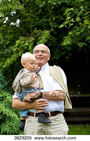 Grandfather carrying toddler outdoors View Large Photo Image Stock Photography - Grandfather carrying toddler outdoors . Fotosearch