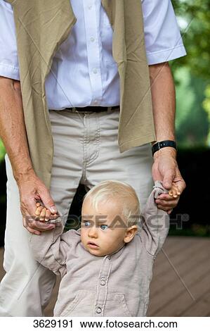 Grandfather helping toddler to walk View Large Photo Image Stock Image - Grandfather helping toddler to walk . Fotosearch