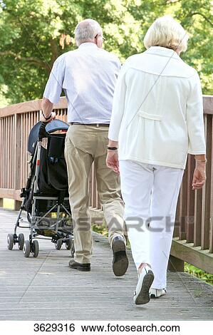 Grandparents going for a walk with grandson in pushchair View Large Photo Image Stock Photograph - Grandparents going for a walk with grandson in pushchair . Fotosearch