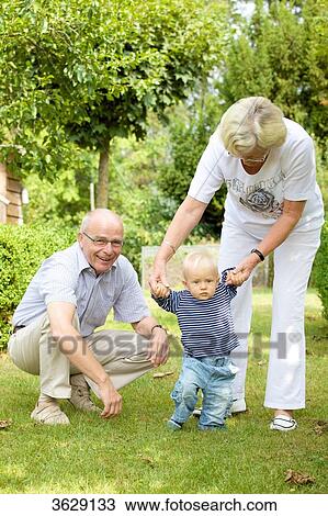 Grandparents with toddler in garden View Large Photo Image Stock Image - Grandparents with toddler in garden . Fotosearch