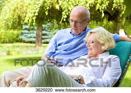 Happy senior couple with smartphone in garden View Large Photo Image Stock Image - Happy senior couple with smartphone in garden . Fotosearch