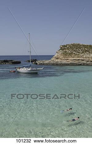 Stock Image - High angle view of couple swimming in bay, Comino Island, Malta . Fotosearch