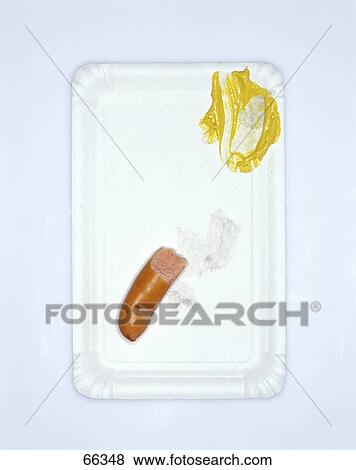 Stock Photo - High angle view of leftover mustard and frankfurter on a plate . Fotosearch