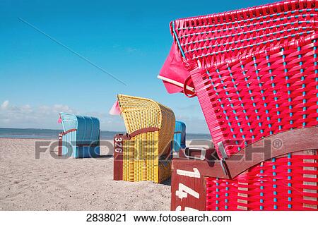 Stock Image - Hooded beach chairs on beach . Fotosearch
