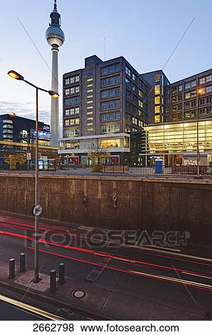 Stock Photo - Lamp post in front of buildings lit up in city . Fotosearch