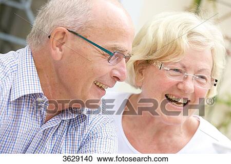 Stock Image - Laughing senior couple outdoors, portrait . Fotosearch