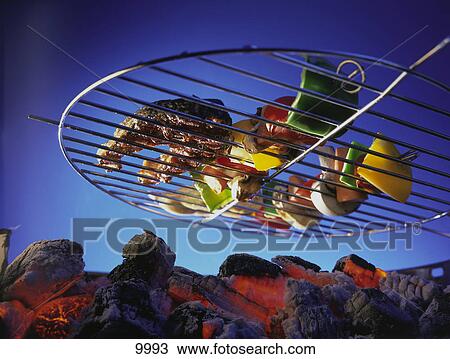 Stock Image - Low angle view of vegetables on barbecue grill . Fotosearch