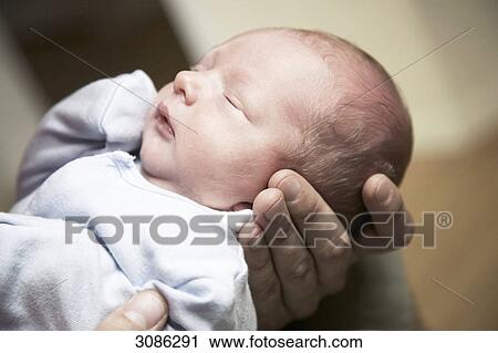 Man holding a sleeping baby in his hands, close-up View Large Photo Image Stock Image - Man holding a sleeping baby in his hands, close-up . Fotosearch