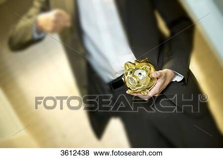 Man in front of safe deposit boxes holding golden piggy bank, close-up View Large Photo Image Stock Photo - Man in front of safe deposit boxes holding golden piggy bank, close-up . Fotosearch
