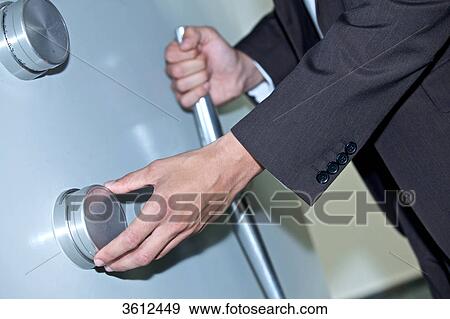 Man opening vault, close-up View Large Photo Image Stock Photo - Man opening vault, close-up . Fotosearch