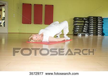 Mature woman exercising on gymnastics mat in gym View Large Photo Image Stock Photo - Mature woman exercising on gymnastics mat in gym . Fotosearch